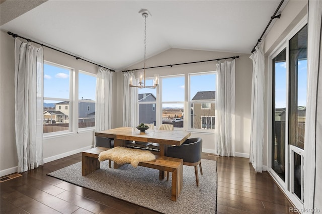 dining area featuring a notable chandelier, dark wood-type flooring, and vaulted ceiling