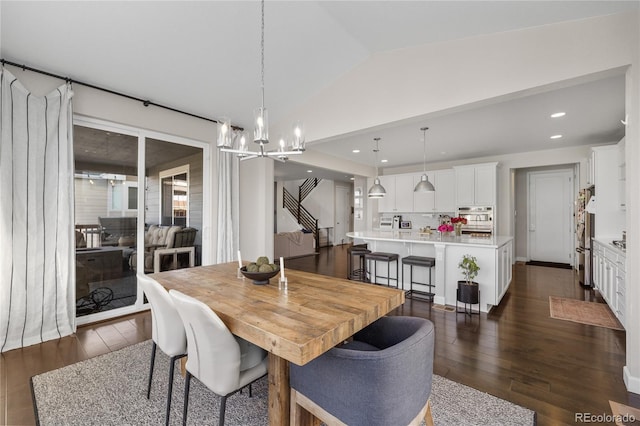 dining space with lofted ceiling, an inviting chandelier, and dark hardwood / wood-style flooring