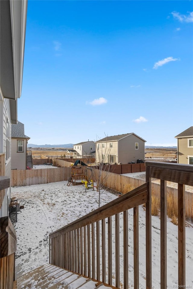 snow covered deck with a playground