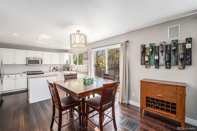 dining space with dark wood-style flooring, baseboards, and recessed lighting
