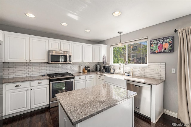 kitchen featuring stainless steel appliances, a sink, tasteful backsplash, white cabinets, and recessed lighting