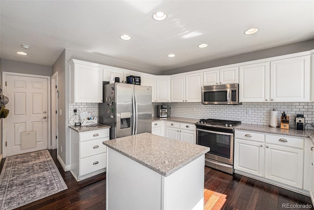 kitchen featuring stainless steel appliances, dark wood-style flooring, light stone counters, backsplash, and recessed lighting