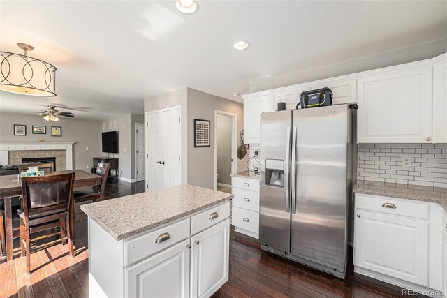 kitchen with stainless steel refrigerator with ice dispenser, ceiling fan, dark wood-type flooring, decorative backsplash, and recessed lighting