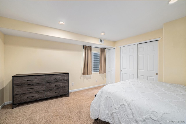 bedroom featuring light colored carpet, baseboards, recessed lighting, and two closets