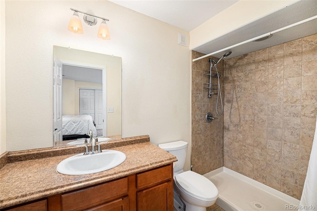 bathroom with toilet, a stall shower, vanity, and ensuite bathroom