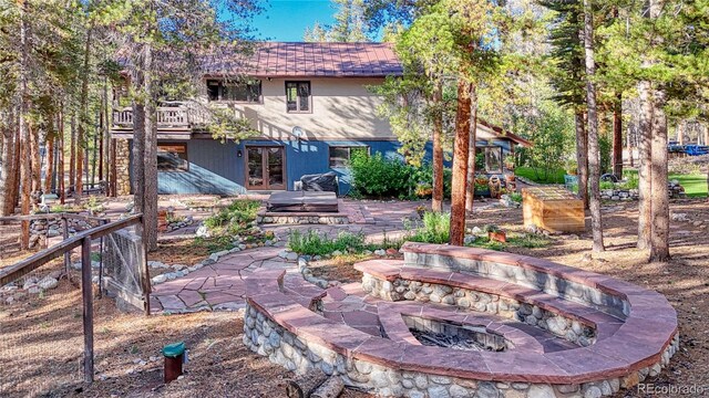 exterior space featuring a patio, a fire pit, and a wooden deck