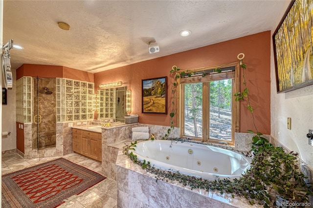 bathroom with separate shower and tub, tile patterned flooring, vanity, and a textured ceiling