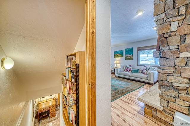 hallway featuring hardwood / wood-style floors and a textured ceiling