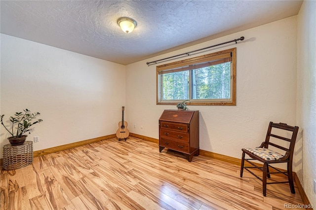 living area featuring light hardwood / wood-style floors and a textured ceiling