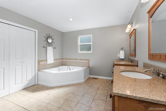 bathroom with tile patterned floors, a bath, and vanity