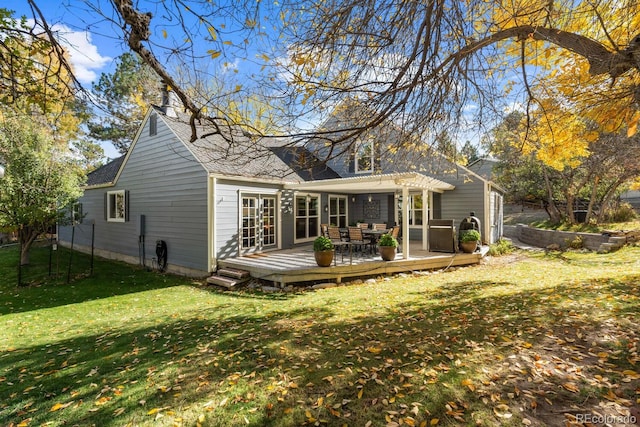 back of property with a pergola, a deck, and a lawn