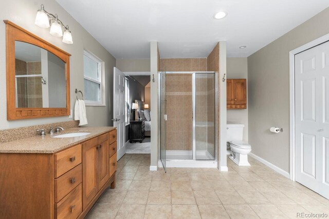 bathroom with walk in shower, tile patterned floors, toilet, and vanity