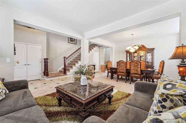 living room featuring a chandelier and stairway