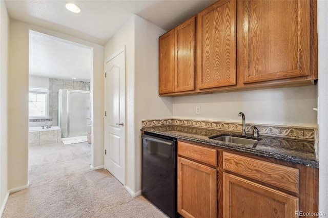 kitchen featuring a sink, dark stone counters, brown cabinets, and black dishwasher