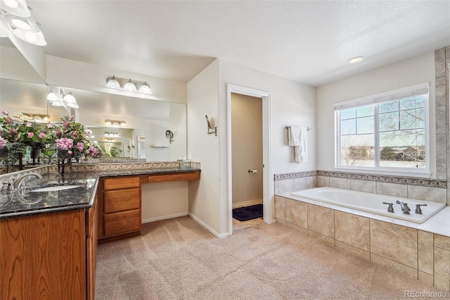 full bathroom featuring vanity, a garden tub, baseboards, and a textured ceiling