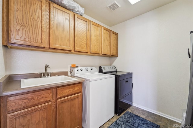 laundry room with visible vents, a sink, washer and dryer, cabinet space, and baseboards