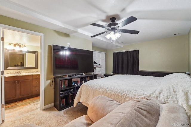 bedroom featuring visible vents, connected bathroom, ceiling fan, light colored carpet, and a sink