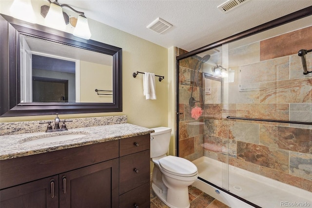 bathroom featuring visible vents, a textured ceiling, toilet, and a stall shower