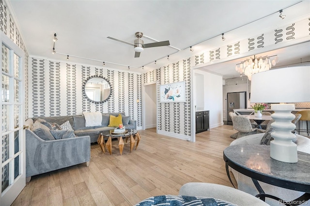 living room with baseboards, wallpapered walls, and rail lighting