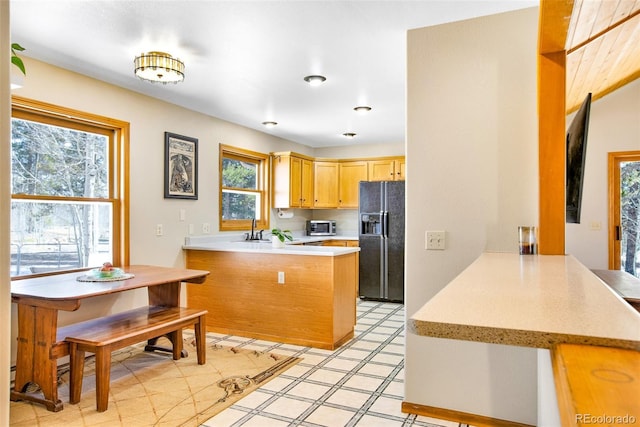 757 Thompson Park Rd, Fairplay, CO 80440 - kitchen with black refrigerator with ice dispenser, a peninsula, light countertops, stainless steel microwave, and a sink