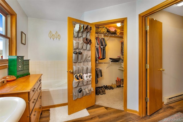 757 Thompson Park Rd, Fairplay, CO 80440 - full bath featuring a baseboard radiator, wood finished floors, a bath, a sink, and a spacious closet