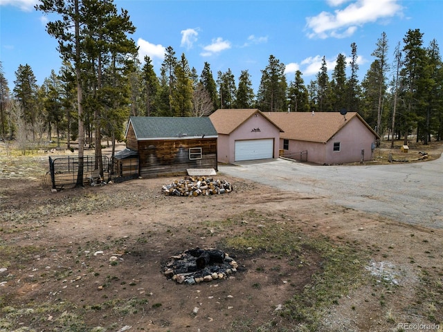 757 Thompson Park Rd, Fairplay, CO 80440 - view of front of property featuring driveway, fence, an attached garage, an outdoor fire pit, and stucco siding