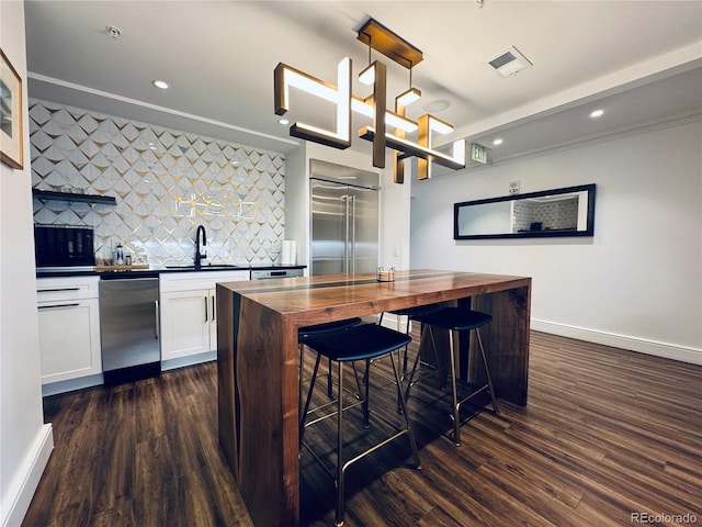 kitchen featuring wooden counters, sink, decorative backsplash, white cabinetry, and stainless steel appliances