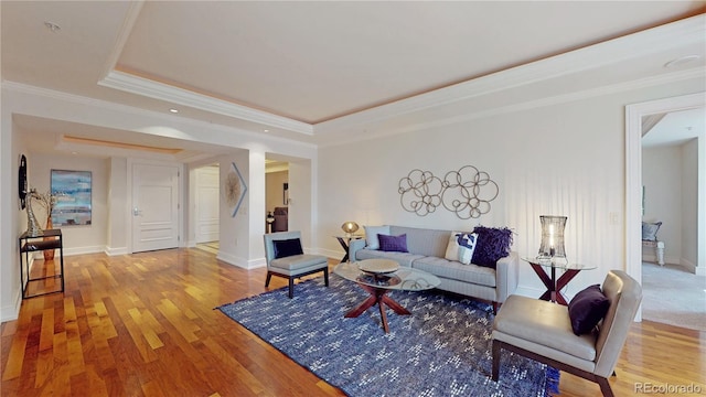 living room featuring a tray ceiling, crown molding, and hardwood / wood-style flooring