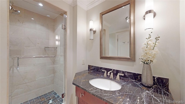 bathroom featuring vanity, a shower with door, and ornamental molding