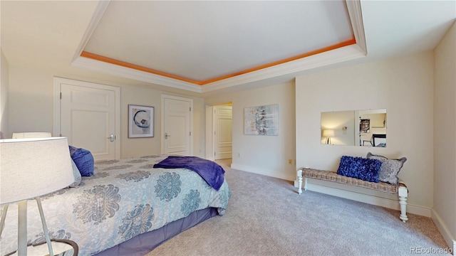 carpeted bedroom featuring a raised ceiling and ornamental molding