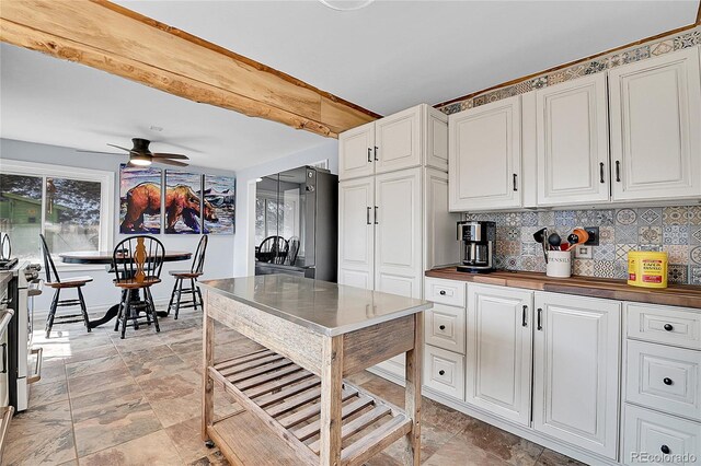 124 River Dr, Bailey, CO 80421 - kitchen with stone finish floors, decorative backsplash, white cabinetry, and beamed ceiling