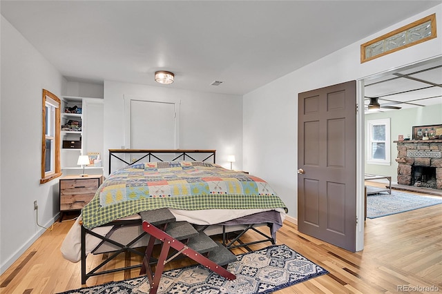 124 River Dr, Bailey, CO 80421 - bedroom featuring light wood-type flooring, baseboards, and a stone fireplace