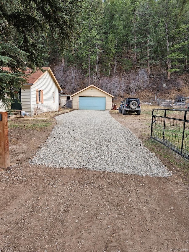 124 River Dr, Bailey, CO 80421 - view of front of home with an outdoor structure, fence, and a garage