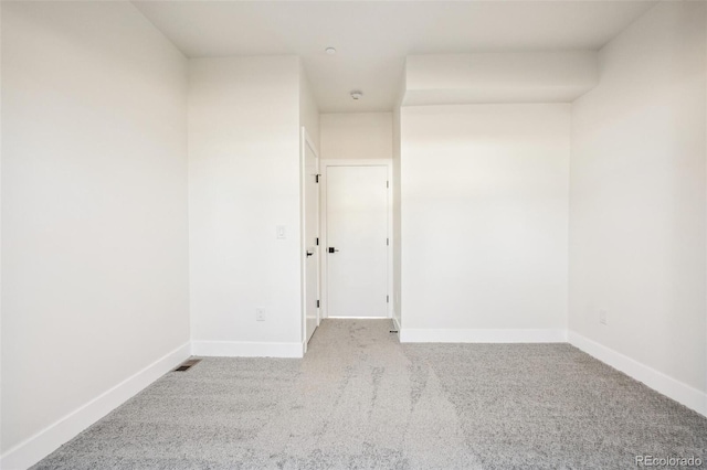 spare room featuring carpet floors and baseboards