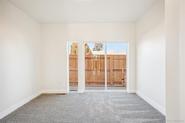 carpeted spare room featuring baseboards