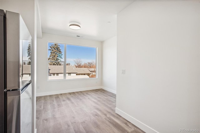 unfurnished room with visible vents, baseboards, and wood finished floors