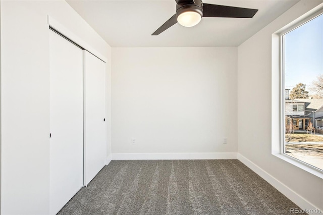 unfurnished bedroom with carpet floors, a closet, a ceiling fan, and baseboards