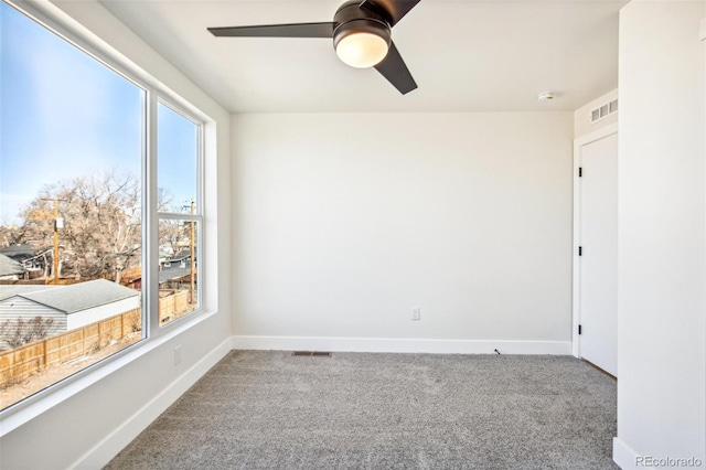 unfurnished room with carpet floors, ceiling fan, visible vents, and baseboards