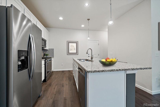 kitchen with sink, decorative light fixtures, stainless steel appliances, and an island with sink