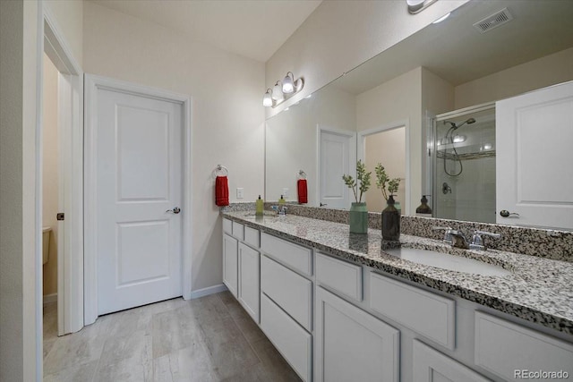 bathroom featuring vanity and a shower with door