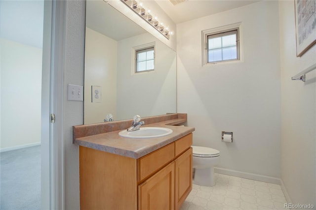 2608 S Troy Ct, Aurora, CO 80014 - half bathroom featuring baseboards, toilet, vanity, and tile patterned floors