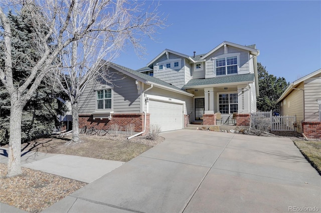 2608 S Troy Ct, Aurora, CO 80014 - craftsman house with brick siding, a porch, an attached garage, and driveway