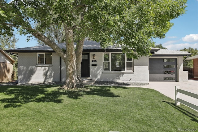 view of front facade featuring a garage, a front yard, brick siding, and driveway