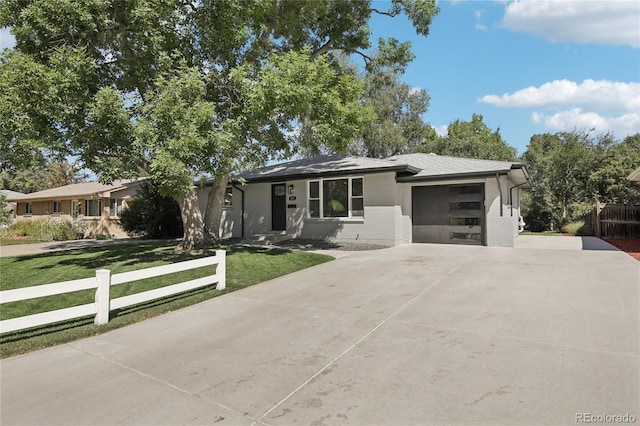 ranch-style home with a garage, driveway, fence, a front yard, and brick siding