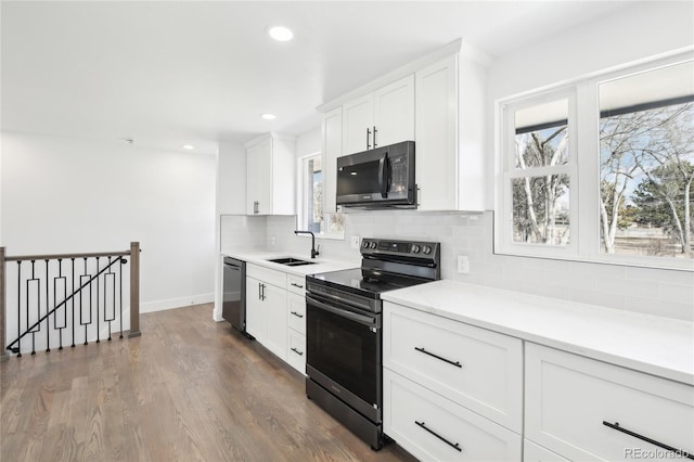 kitchen featuring tasteful backsplash, dishwashing machine, stainless steel electric range oven, black microwave, and a sink