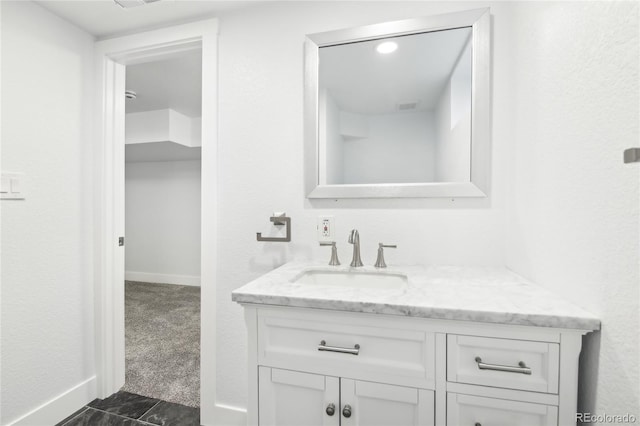 bathroom featuring visible vents, vanity, and baseboards