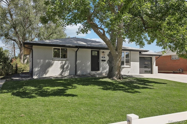 view of front of property with a garage, driveway, a front yard, and brick siding