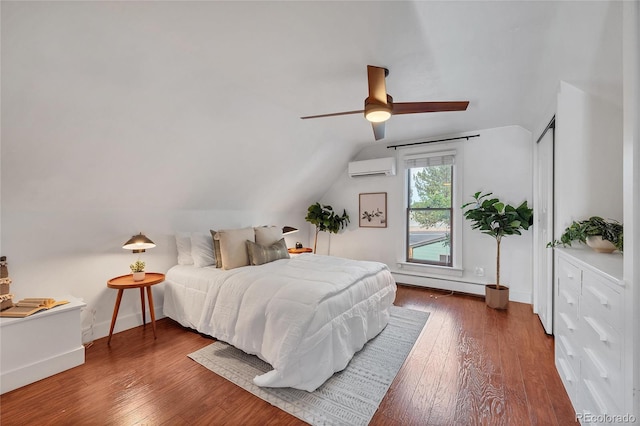 bedroom featuring ceiling fan, wood-type flooring, vaulted ceiling, and a wall mounted AC