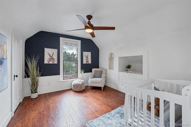 bedroom featuring ceiling fan, wood-type flooring, a crib, and lofted ceiling