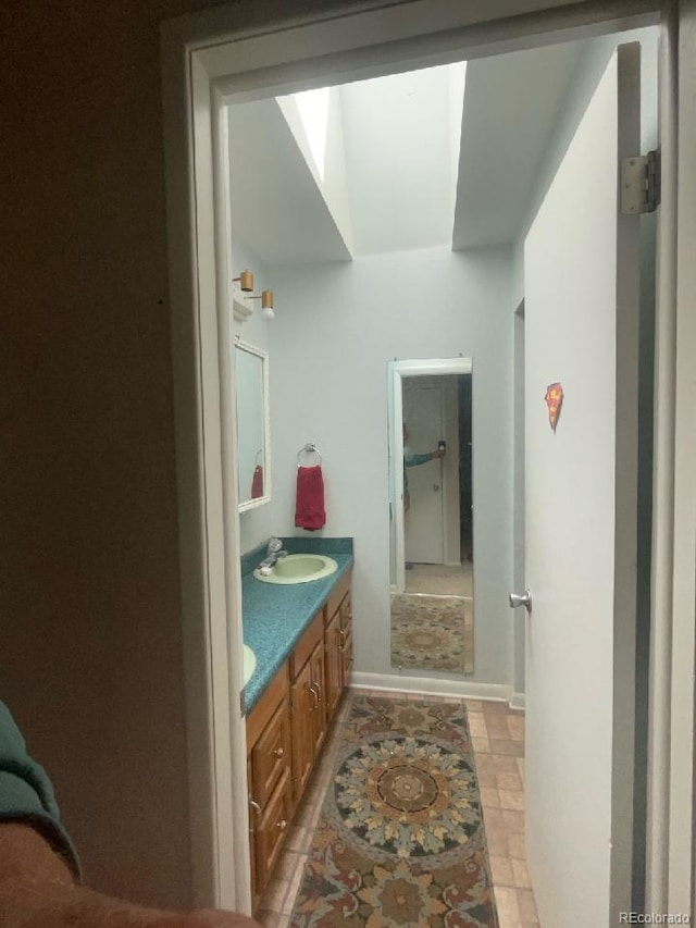 bathroom featuring a sink, baseboards, and double vanity